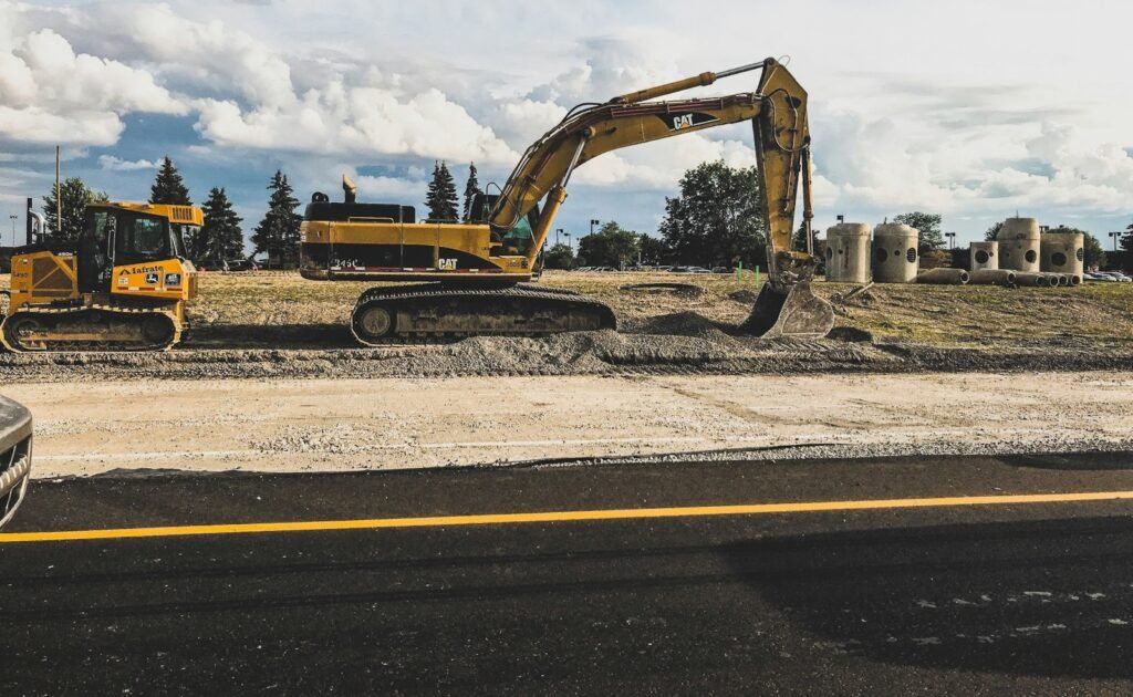 yellow Caterpillar excavator digging up dirt